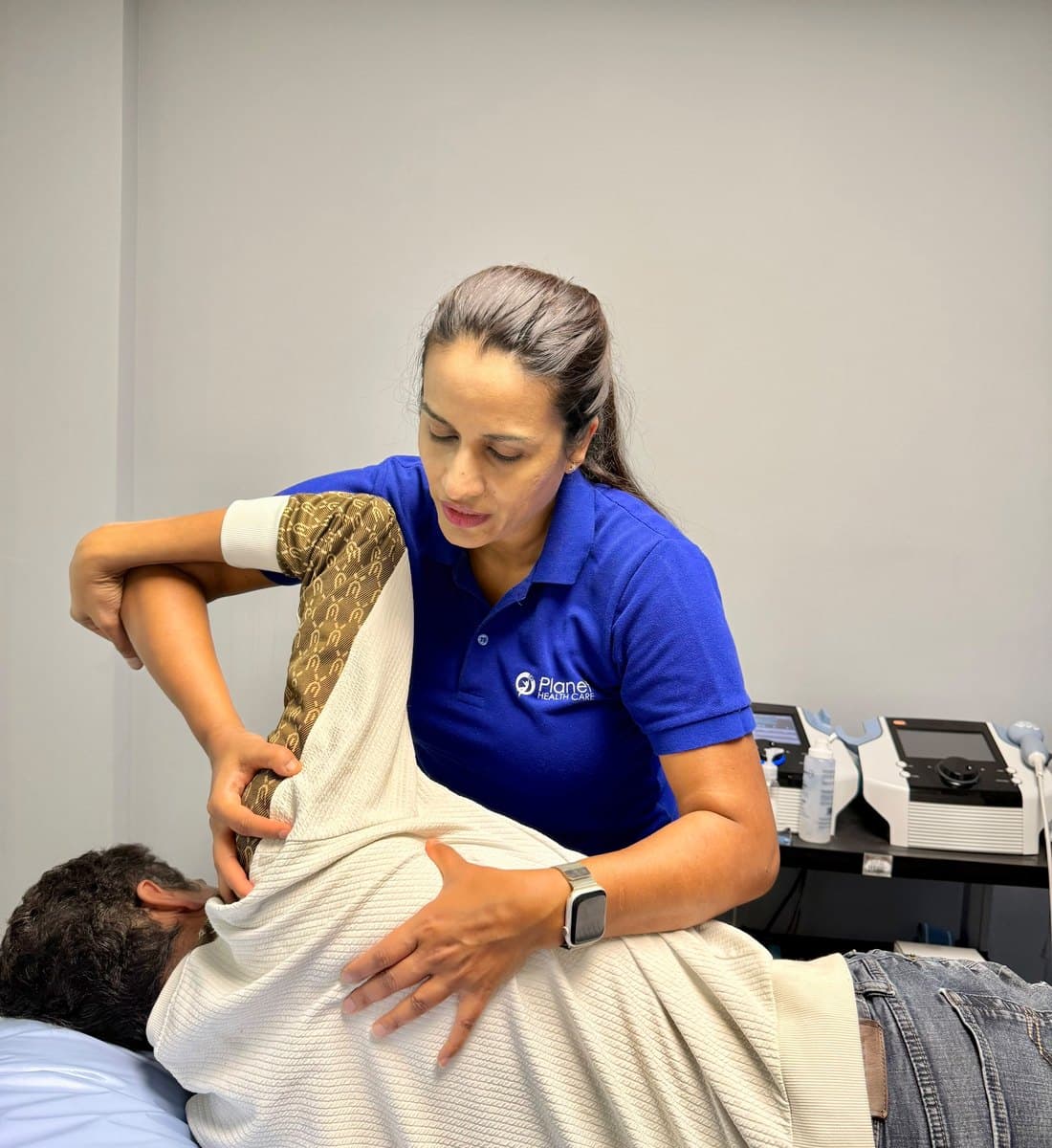 Hiral Desai providing manual physiotherapy treatment in a Planet Health Care treatment room