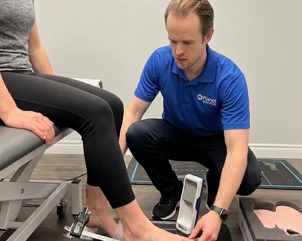 Certified pedorthist assessing a patient foot for custom orthotics at Planet Health Care